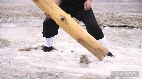 Stock Footage of Person Training With Log Lifting In Middle Of Frozen Lake 4K