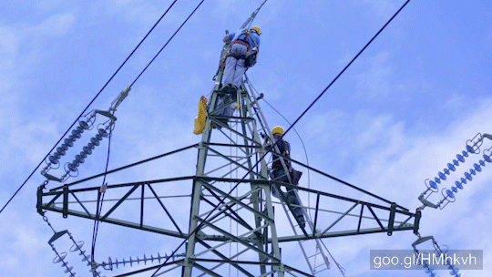Professional workers repairing power lines in dangerous situation. Unrecognized persons high on power pillar.