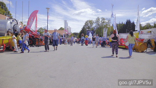 Camera on gimbal stabilizer slowly moving forwards with wide view and people in fast motion passing by. 
